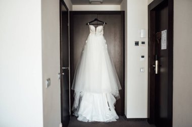 Törenden önce, omuzlarında beyaz gelinlik.