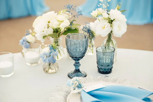 파란색 식탁보를 손님을 테이블 꽃으로 장식된 — 스톡 사진