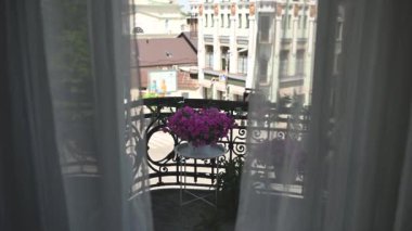 Tulle ve şehir manzaralı klasik bir balkonda güzel çiçekler..
