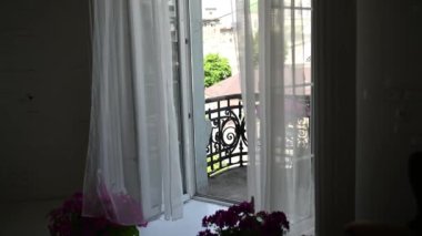 Tulle ve şehir manzaralı klasik bir balkonda güzel çiçekler..