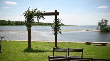 Arka planda düğün kemeri ve ahşap sandalyeler güzel nehirde. Çiçeklerle süslenmiş ahşap kemer..