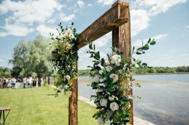 Arka planda düğün kemeri ve ahşap sandalyeler güzel nehirde. Çiçeklerle süslenmiş ahşap kemer..