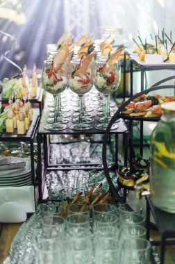 Yaratıcı disko ışıklandırması olan bir partide farklı tipte abur cuburlarla dolu büyük bir masa. Çeşitli atıştırmalıklar, et, bardakta meyve ve daha fazlası..