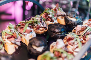 Yaratıcı disko ışıklandırması olan bir partide farklı tipte abur cuburlarla dolu büyük bir masa. Çeşitli atıştırmalıklar, et, bardakta meyve ve daha fazlası..