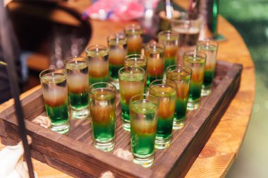 Farklı kokteylli bardaklar. Disko ışıklandırmalı bir partide uzun ve kısa kokteyller..