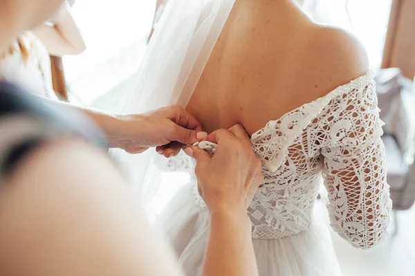 伴娘帮新娘系好紧身胸衣 穿上婚纱 为婚礼当天早上做准备 — 图库照片