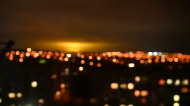 Gece şehrinin bulanık görüntüsü. Akşam ışıkları gökyüzünü aydınlatıyor. Soyut parlak bulanık renkli bokeh. Şehir arka planında Bokeh ışıkları