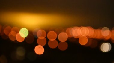 Gece şehrinin bulanık görüntüsü. Akşam ışıkları gökyüzünü aydınlatıyor. Soyut parlak bulanık renkli bokeh. Şehir arka planında Bokeh ışıkları