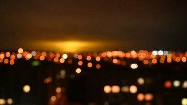 Gece şehrinin bulanık görüntüsü. Akşam ışıkları gökyüzünü aydınlatıyor. Soyut parlak bulanık renkli bokeh. Şehir arka planında Bokeh ışıkları