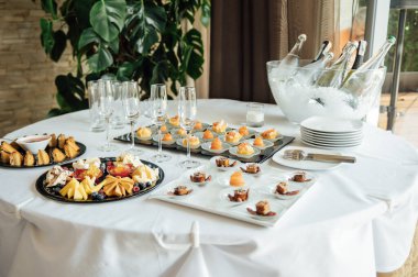 Masada konuklar için çok çeşitli atıştırmalıklar var. Karides, haşlanmış domuz eti, çeşitli et ve diğer ürünler..