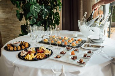 Masada konuklar için çok çeşitli atıştırmalıklar var. Karides, haşlanmış domuz eti, çeşitli et ve diğer ürünler..