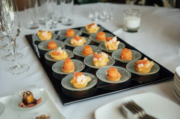 A wide variety of snacks on the table for guests. Shrimp, boiled pork, various types of meat and other products.