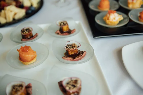 A wide variety of snacks on the table for guests. Shrimp, boiled pork, various types of meat and other products.