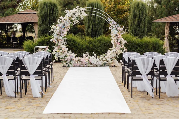 Wedding ceremony. Very beautiful and stylish wedding arch, decorated with various fresh flowers.