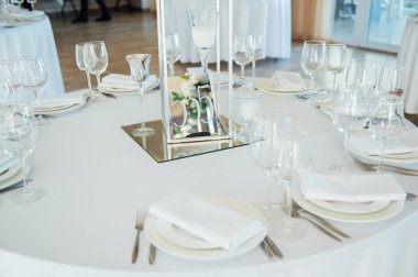 Lüks restoran. Lüks içecekler, beyaz masalar, misafirler için servis tabakları ve bardaklar..