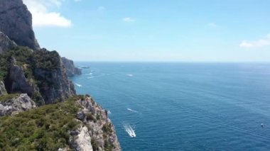 İtalya 'nın Capri kentinin yukarısından, yüksek sahil kayalıkları ve yazın güzel bir gökyüzü ile Akdeniz manzarası (4K)
