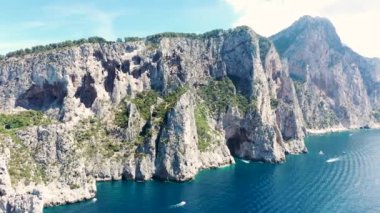 İtalya 'nın başkenti Capri' de yaz mevsiminde Akdeniz 'in üzerindeyken sahil uçurumlarının havadan görünüşü (4K)