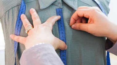 woman sewing shirt on mannequin