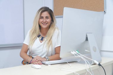 Ofisteki dizüstü bilgisayarda çalışan genç kadın.