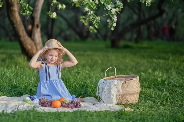 Gelukkige kleine meid die plezier heeft in het park. Leuk kind zittend op het gras op een zonnige zomerdag — Stockfoto