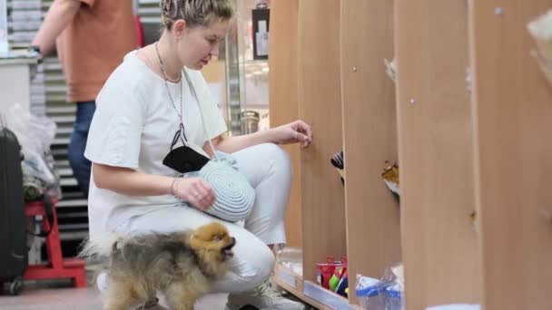 09.05.2021 - Moskou, Rusland - vrouwelijke kunstenaar in een kunsthandel selecteert goederen. moderne vrouw doet aankopen in de supermarkt. — Stockvideo
