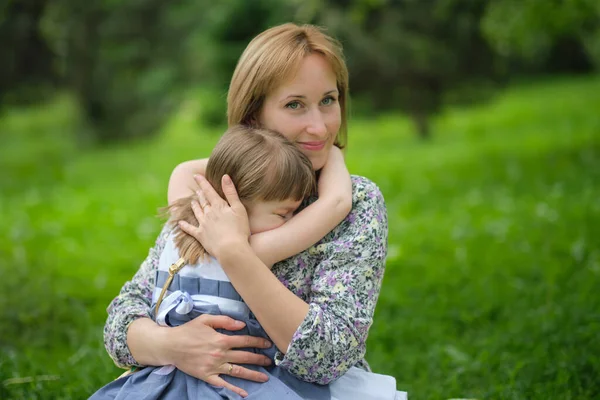 Πλάγια άποψη κοντά στο κεφάλι πυροβόλησε ευτυχισμένη χαριτωμένο κόρη αγκαλιάζει αγκαλιά μητέρα. Έννοια της ευτυχισμένης οικογένειας. Πορτρέτο χαρούμενο χαμογελαστό παιδί αγκαλιάζει τη μητέρα το καλοκαίρι — Φωτογραφία Αρχείου