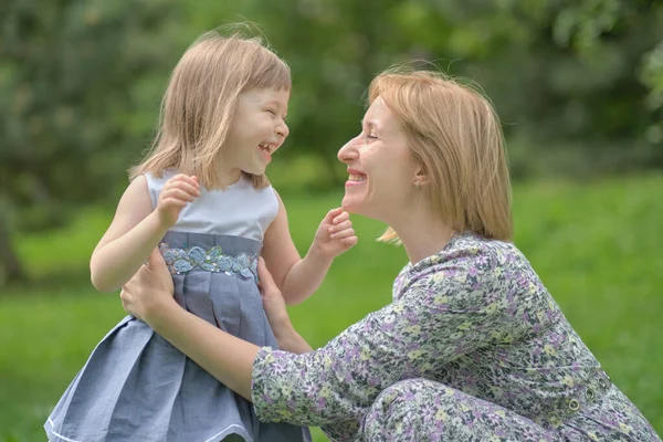 一个可爱的小女孩和她的妈妈在散步。妈妈和小女孩在花园里玩耍。与女儿拥抱并在户外玩得开心的女人. — 图库照片
