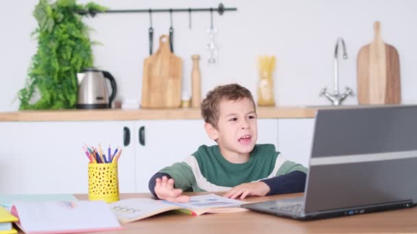 怒った少年は教科書を押しのけてノートパソコンを持ち上げる。子供は勉強を拒否し. — ストック動画