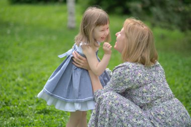 Annesiyle birlikte yürüyüş yapan tatlı bir kız. Anne ve çocuk bahçede oynuyorlar. Kızı olan bir kadın dışarıda eğleniyor..