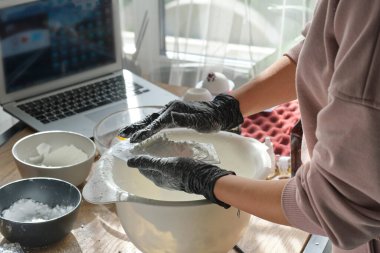 Kadın online ders alıyor ya da banyo bombaları hakkında bir video izliyor. Çevrimiçi eğitim, online dersler. Usta el yapımı kozmetik ürünler üretiyor