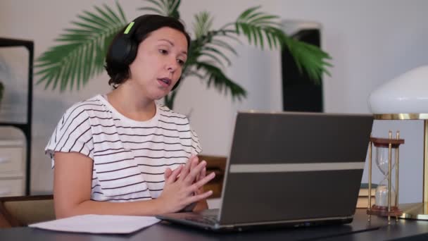 Giovane donna indossa cuffie conferenza chiamata su computer portatile colloqui con insegnante online studiare, lavorare da casa . — Video Stock