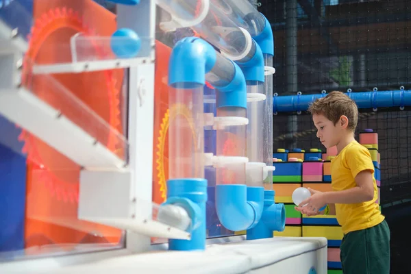 Fascinerande fysik med en labyrint av rör. Genom att göra experimenten får barnet praktiska färdigheter och förstår att lärande är roligt. — Stockfoto