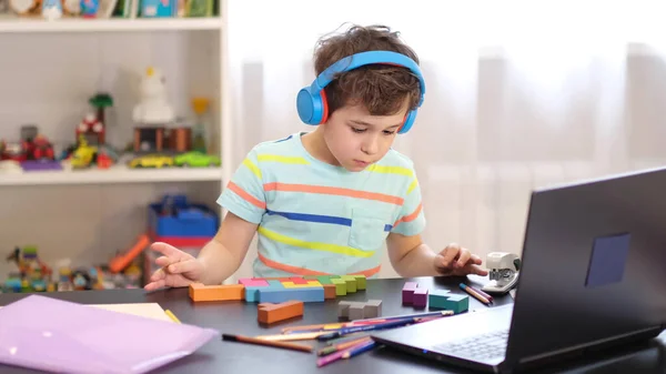 Lernen Sie auf Ihrem Stundenplan. Online-Fernunterricht. Ein Schuljunge lernt zu Hause und macht Hausaufgaben. Ein Fernstudium zu Hause. — Stockfoto