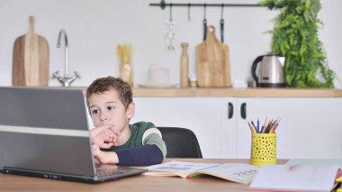 Çocuk çevrimiçi bir okulda okuyor ve bu sorunun cevabını video iletişimiyle gösteriyor.