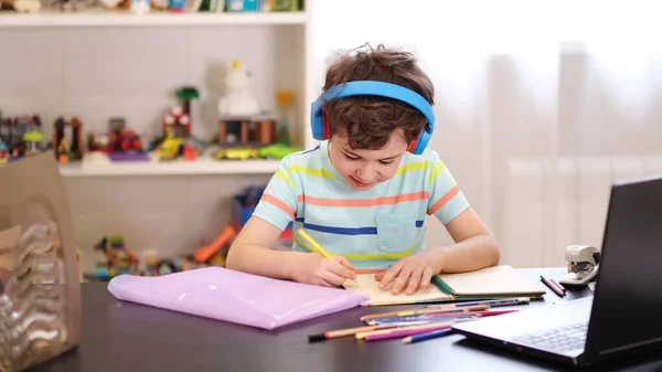 Lernen Sie auf Ihrem Stundenplan. Online-Fernunterricht. Ein Schuljunge lernt zu Hause und macht Hausaufgaben. Ein Fernstudium zu Hause. — Stockfoto