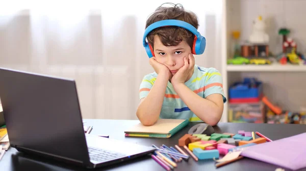 Ucz się w swoim grafiku. Kształcenie online na odległość. Zmęczony smutny chłopak uczący się w domu online na laptopie. Koncepcja uczenia się na odległość w czasie kwarantanny — Zdjęcie stockowe