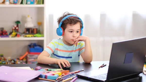 Renseignez-vous sur votre horaire. Enseignement à distance en ligne. Un écolier étudie à la maison et fait ses devoirs à l'école. Un enseignement à distance à domicile. — Photo