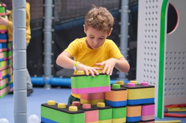 Küçük çocuk roket yapımı için taş kullanıyor. Çocuklar öğrenme ve geliştirme konsepti. duyusal oda, bağımsız oyun