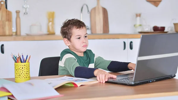 Chłopiec uczy się w szkole online, pokazując odpowiedź na pytanie poprzez komunikację wideo — Zdjęcie stockowe