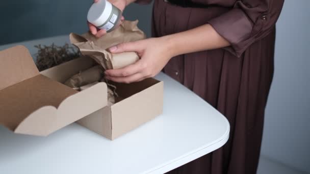 Frau öffnet Paket drinnen. Frau öffnet und packt Pappkartonpaket im heimischen Wohnzimmer aus. guter Lieferservice. — Stockvideo