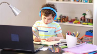 Programından öğren. Uzaktan öğrenme çevrimiçi eğitim. Bir okul çocuğu evde ders çalışır ve okul ödevi yapar. Evden öğrenme.