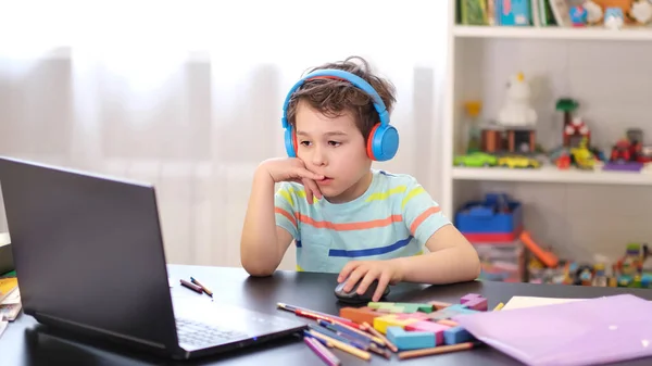 Дізнайтеся про свій графік. Дистанційне навчання онлайн-освіти. Хлопчик вчиться вдома і робить шкільне домашнє завдання. Навчання на домашній дистанції . — стокове фото