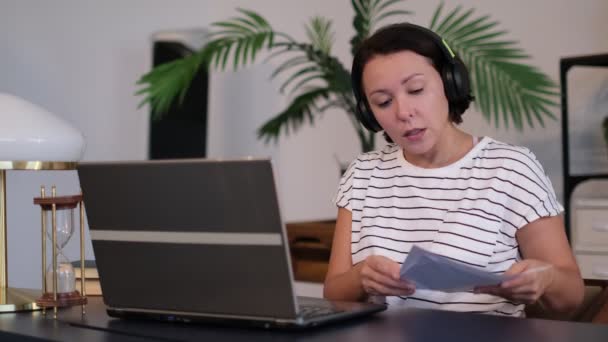 Junge Frau trägt Headset-Konferenz telefoniert auf Laptop Gespräche mit Online-Lehrer studieren, arbeiten von zu Hause aus. — Stockvideo