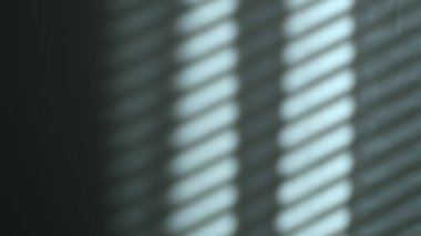 Sabah güneşi odayı aydınlatıyor, arka plan gölgeli. Duvardaki panjurların yansıması, çizgili gölgeler. Rüzgardan perdelerin yavaş hareketi