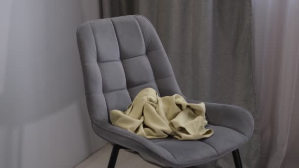 Personne jette des vêtements usagés sur la chaise. Pile vêtements sur la chaise. tas de vêtements usagés pour le don et le recyclage. Concept de minimalisme, désordre et nettoyage des armoires — Video