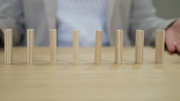 Mão empresário impedindo blocos coloridos de cair na mesa no escritório. efeito dominó nas empresas. — Vídeo de Stock