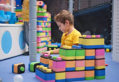 Küçük çocuk roket yapımı için taş kullanıyor. Çocuklar öğrenme ve geliştirme konsepti. duyusal oda, bağımsız oyun