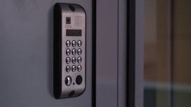 Erkek, elektronik şifre kilidini açar. Man hand giriş güvenlik sistemi kodu, modern dahili haberleşme aygıtı üzerinde işaret parmağı ile tuşuna basarak giriş kapısı yakınında mavi lcd ekran.