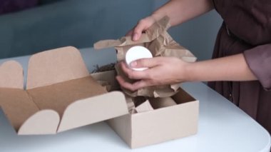 Karton kutuyu açan kadın az önce adrese bir paket bıraktı. Eve posta teslimatı.