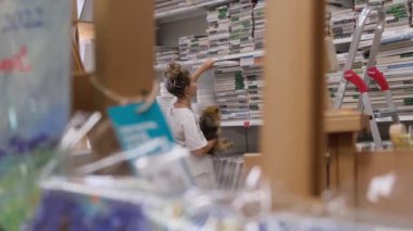 09.05.2021 - Moskova, Rusya - bir sanat mağazasındaki kadın sanatçı ürünleri seçiyor. Modern kadın süpermarketten alışveriş yapıyor..